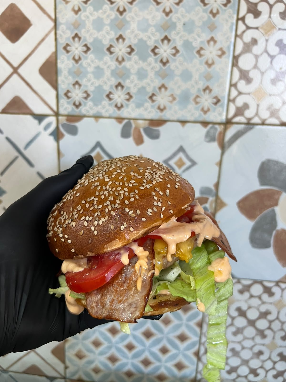 Panino gourmet con carne alla griglia, pomodoro, insalata e salsa, servito al Bar Panineria Rocca